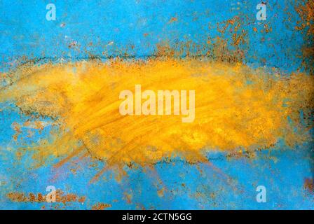 Peeling blue orange paint on a metal surface exposing underlying rusty metal Stock Photo