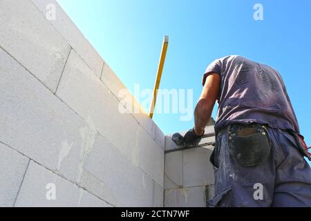 Construction worker (bricklayer) works on the construction site Stock Photo
