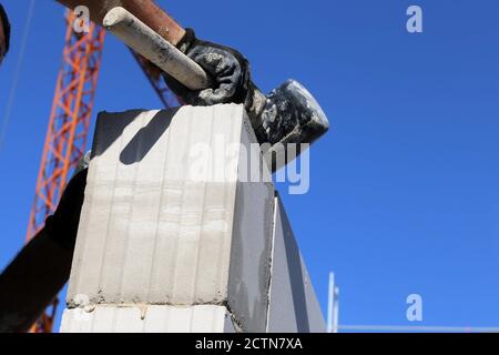Construction worker (bricklayer) works on the construction site Stock Photo