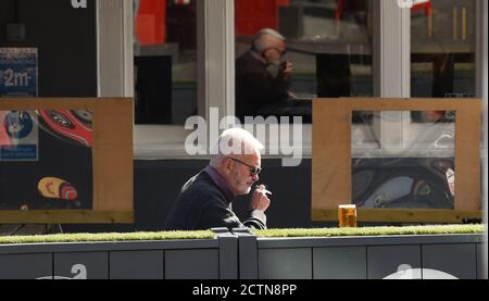 Brighton UK 24th September 2020 - A man enjoys a pint outside a pub in Brighton as the new government COVID restrictions are brought in throughout England today with pubs and restaurants having to close at 10pm tonight : Credit Simon Dack / Alamy Live News Stock Photo
