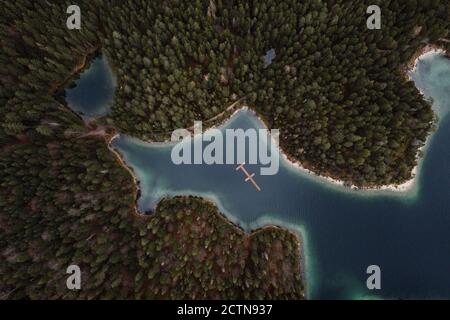 From above of majestic landscape of woods with coniferous trees and lakes with turquoise water on overcast day