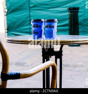 Two Disposable Blue Caffe Nero Disposable Cups On A Table Top With No People Stock Photo