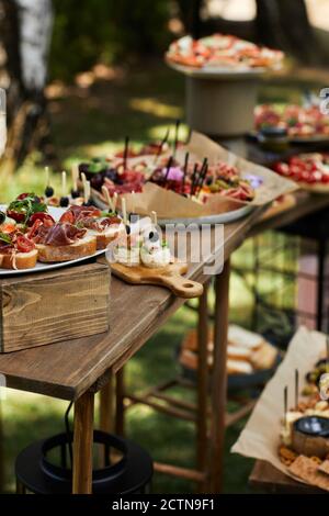 wooden buffet table with snack, appetizer and fruits decorated outdoor in summer day Stock Photo