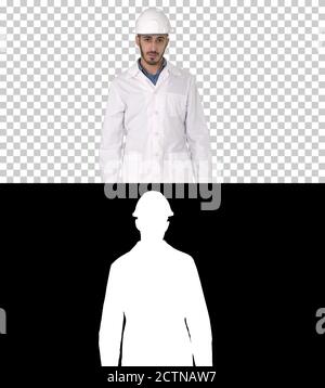 Arab engineer in helmet and white robe walking forward, Alpha Ch Stock Photo