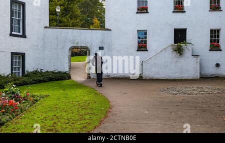 North Berwick, East Lothian, Scotland, United Kingdom, 24th September 2020. A man on an electric scooter in Lodge Grounds garden