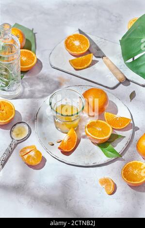 Top view of whole and half of ripe oranges arranged on table with knife and glass with juice Stock Photo
