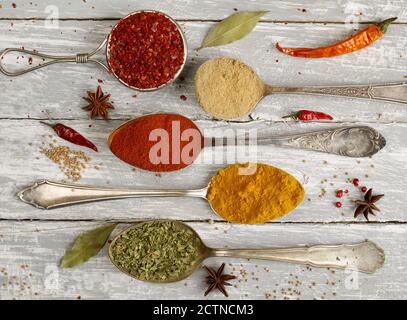 Spoons with a variation of condiments on wood Stock Photo