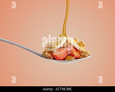 Breakfast cereal on a spoon with honey pouring Stock Photo