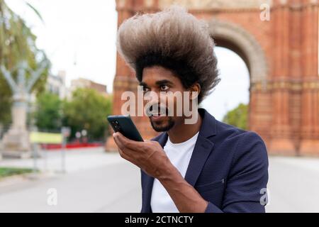 Young black man in a suit standing on the street talking on the mobile phone Stock Photo