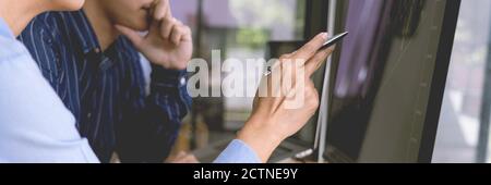 broker showing some ascending to his colleague planning and analyzing graph stock market trading with stock chart data on multiple computer screens Stock Photo