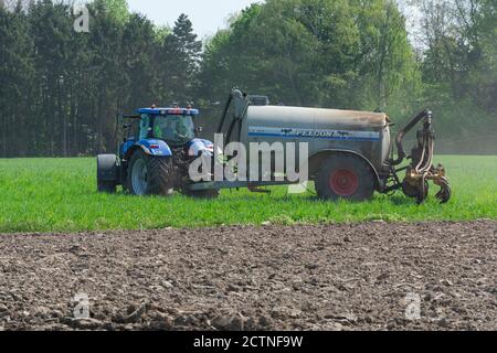 Sint Gillis Waas, Belgium, April 15, 2020, Farmer is fertilizing the field with his tractor Stock Photo