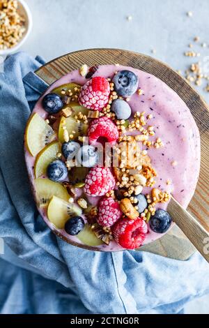 Top view of nutritious breakfast bowl with berries and yogurt served on table in morning Stock Photo
