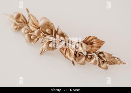 High angle of handmade hairpin with golden flowers and leaves placed on table in workshop Stock Photo