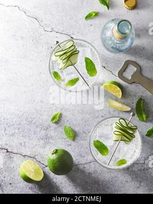 From above of refreshing Mojito cocktails in glasses with ice cubes arranged on table with lime slices Stock Photo