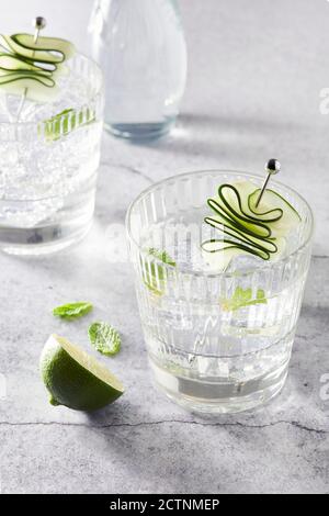 Refreshing Mojito cocktails in glasses with ice cubes arranged on table with lime slices Stock Photo