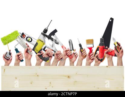 Hands raised holding different tools and wood board Stock Photo