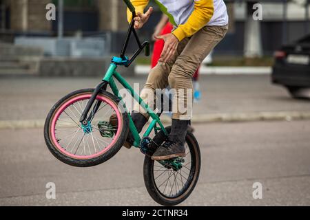 Bmx rider on black bmx in doing acrobtic stunts in the street. Urban male sports outdoor activity concept. Stock Photo