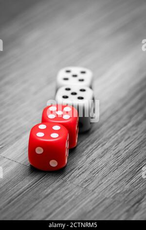 Four game dices on the floor with numbers five and four, black and white image with selected red colour Stock Photo