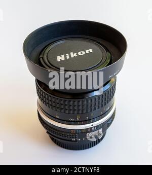 Nikon Nikkor 28mm 1:3.5 lens with Nikon metal lens hood and cap. Stock Photo