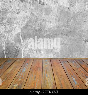 Room interior: grey damaged cement wall with brown wooden floor Stock Photo