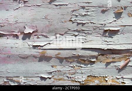 Cracked paint on a wooden wall. Wall from wooden planks with paint traces. Grunge background, cracked paint. Stock Photo