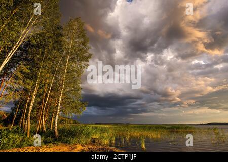 Amazing sunset at the Braslaw lakes with the cloudy sky. Braslaw district, Belarus. Stock Photo
