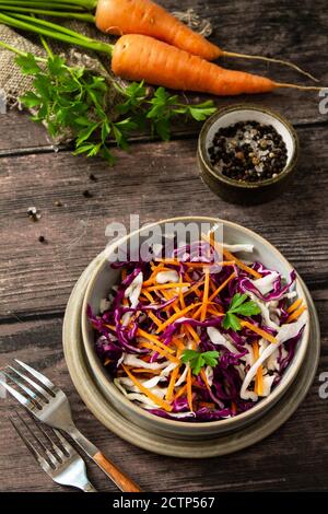Salad Cole Slaw. Cabbage salad in a bowl on a rustic wooden table. Stock Photo