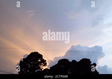 sun rays come from behind clouds Stock Photo
