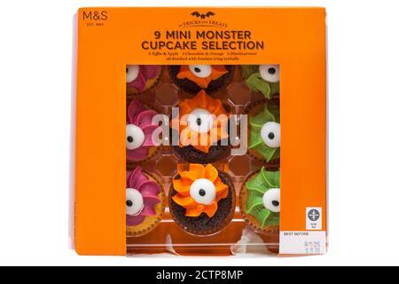box of M&S mini monster cupcake selection - mini monster cupcake cakes finished with fondant icing eyeball for Halloween isolated on white background Stock Photo