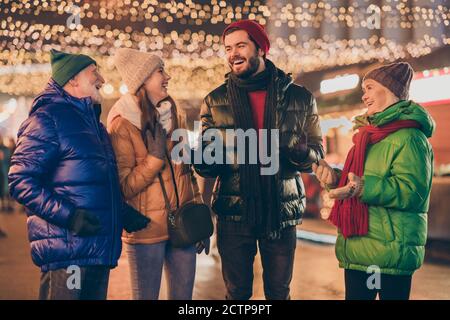 Photo of full family four members x-mas meeting chatting laughing grandpa tell joke wear outerwear hat scarf coat gloves multi-generation night street Stock Photo
