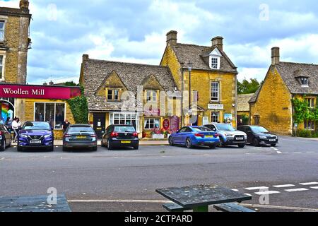 Typical small buildings built of the warm Cotswold stone, in the centre of this pretty village.Small Talk Tearooms  and Cotswold Distillery Stock Photo