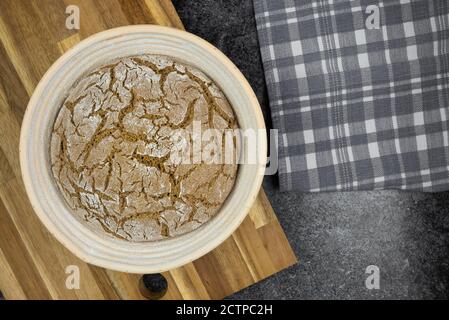 above view of proofing pure rye sourdough bread in banneton on kitchen counter Stock Photo