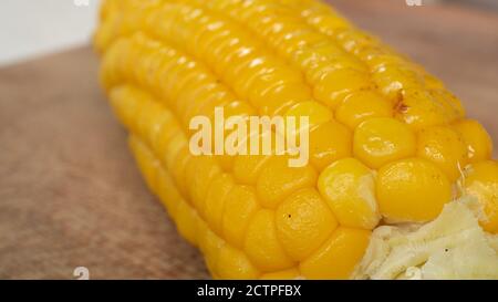 Delicious corn on the cob captured in an extreme close up. The brightly glowing yellow kernels form a recognizable pattern. Stock Photo