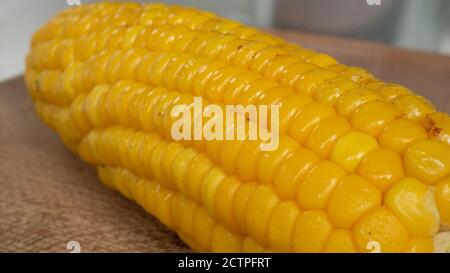 Delicious corn on the cob captured in an extreme close up. The brightly glowing yellow kernels form a recognizable pattern. Stock Photo