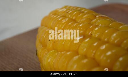 Delicious corn on the cob captured in an extreme close up. The brightly glowing yellow kernels form a recognizable pattern. Stock Photo