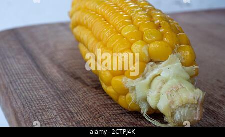 Delicious corn on the cob captured in an extreme close up. The brightly glowing yellow kernels form a recognizable pattern. Stock Photo