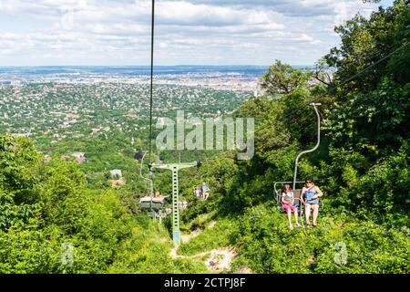 Budapest, Hungary – June 5, 2017. Chairlift connecting Elizabeth Lookout tower to Zugligeti ut. in Budapest, with people. Stock Photo