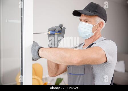 Worker man installs plastic windows and doors with double-glazed white Stock Photo