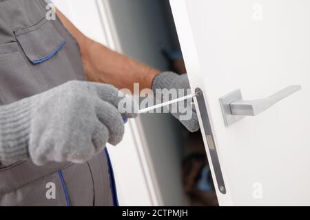 Carpenter worker in medical mask process installation door wood Stock Photo