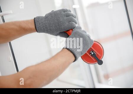 Worker man installs plastic windows and doors with double-glazed white Stock Photo