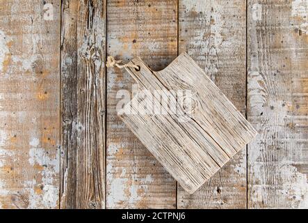 Wooden distressed weathered background with kitchen board Stock Photo