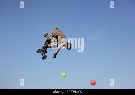 Young man skateboarding in the air with blue sky in France during Fête de l’humanité in France Stock Photo
