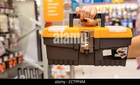Woman holding orange heavy duty plastic tool box at the store Stock Photo