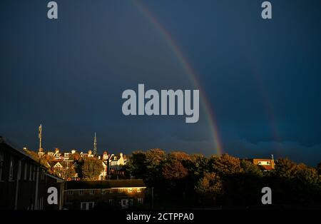 Brighton UK 24th September 2020 - A stunning rainbow above the Queens Park area of Brighton after heavy downpours of rain with more unsettled weather forecast for the area over the next few days : Credit Simon Dack / Alamy Live News Stock Photo