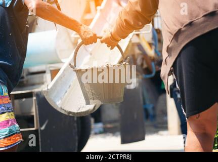 Construction workers helped cement bucket loaders to be introduced into a points set. Stock Photo