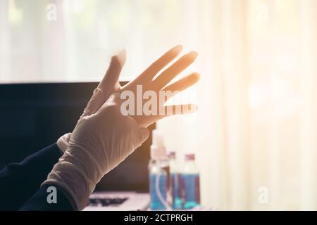 Doctor putting on white sterilized surgical gloves Stock Photo