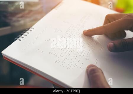 Close-up of fingers reading braille, Hand of a blind person reading some braille text of a braille book. Stock Photo