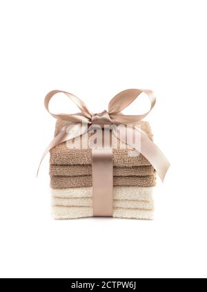 Gift set of white and light brown Terry towels with a satin ribbon on a white background. Stock Photo