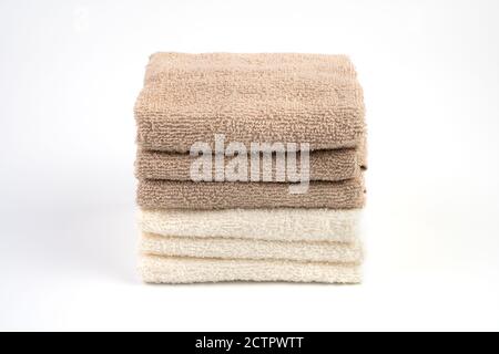 Terry towels are white and light brown on a white background. Stock Photo