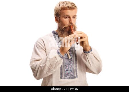 Bearded man in ethnic clothes playing a wooden flute isolated on white background Stock Photo